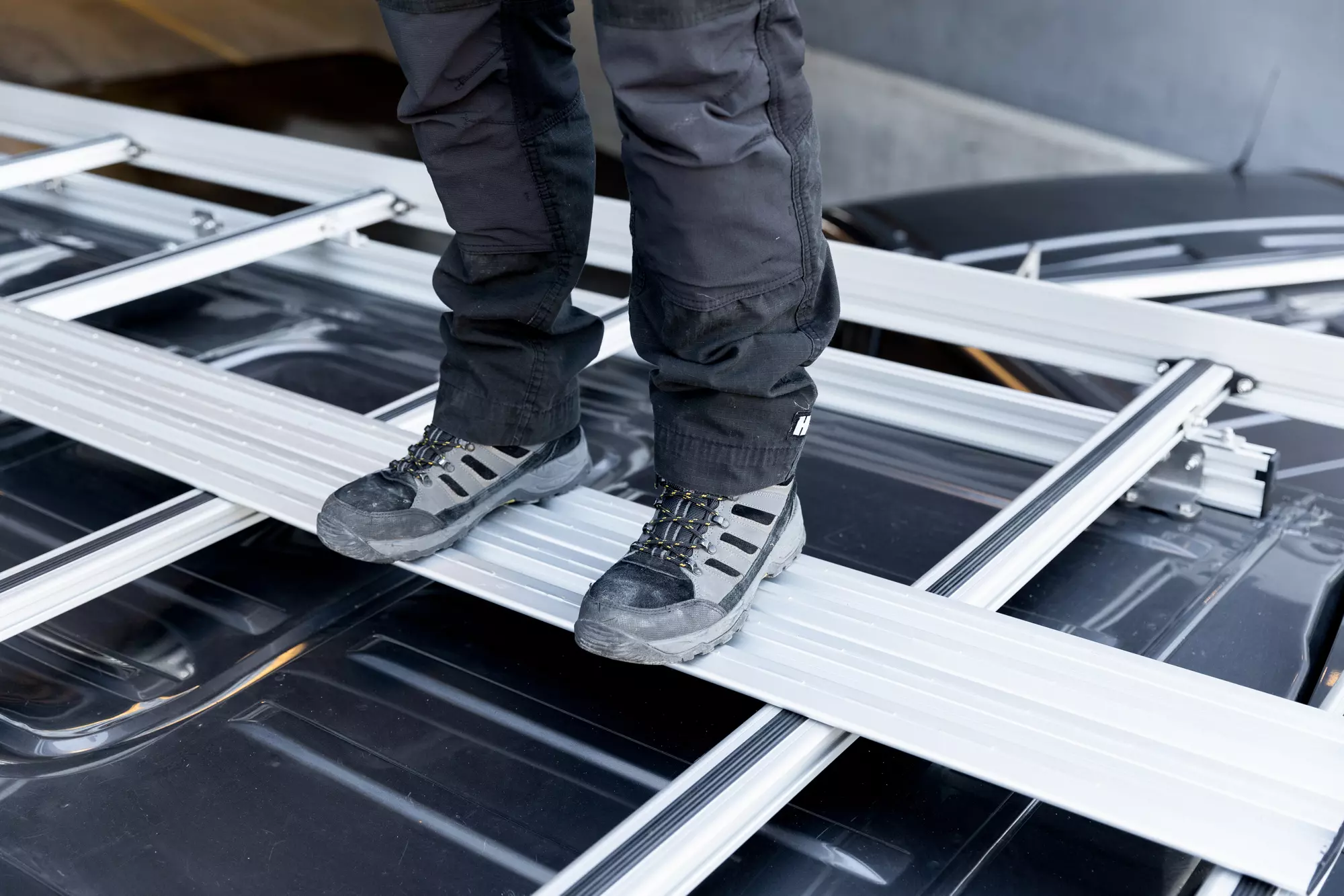 Handwerker steht auf dem stabilen Aluminium-Trittbett eines mobietec Dachträgers